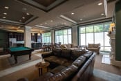 Thumbnail 5 of 22 - Club room at Residences of Creekside with brown leather couches and pool table.