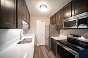 Thumbnail 5 of 17 - Renovated kitchen with stainless appliances and quartz countertops