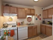 Thumbnail 6 of 13 - Kitchen with light wood cabinets, tile flooring and white appliances