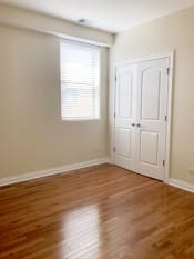 Thumbnail 19 of 23 - a bedroom with hardwood floors and a white door with a window