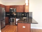 Thumbnail 7 of 23 - a kitchen with black granite countertops and stainless steel appliances