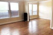 Thumbnail 29 of 38 - an empty living room with hardwood floors and three windows