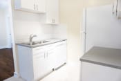 Thumbnail 27 of 38 - a small kitchen with white cabinets and a stainless steel sink