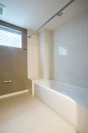 Thumbnail 14 of 24 - a bathroom with white tile and a white bathtub