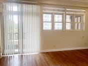 Thumbnail 14 of 23 - an empty living room with white blinds on the windows