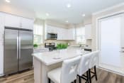 Thumbnail 50 of 60 - a white kitchen with stainless steel appliances and white chairs