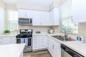 Thumbnail 52 of 60 - a kitchen with white cabinets and stainless steel appliances