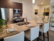 Thumbnail 3 of 21 - Phoenix, AZ Luxury Apartments For Rent - Level At Sixteenth - Kitchen With Island, Wooden Cabinets, And Stainless-Steel Appliances