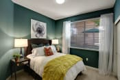 Thumbnail 1 of 48 - One, Two, and Three-Bedroom Apartments in San Jose, CA - Aviara - Bedroom with Plush Carpeting, a Side Window, Dark Green Walls, and Stylish Decor