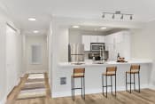 Thumbnail 35 of 57 - a kitchen with a breakfast bar, bar stool, white cabinetry and stainless appliances
