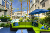 Thumbnail 12 of 21 - Phoenix Luxury Apartments - Level At Sixteenth - Outdoor Lounge With Sun Umbrella, View Of Pool, And Green Patio Sectional Couch
