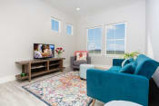 Thumbnail 10 of 84 - Mihir Taylor model living room with blue furniture and a tv