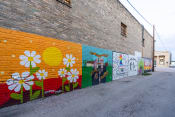 Thumbnail 44 of 84 - a mural on the side of a brick wall with flowers