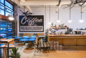 Thumbnail 50 of 84 - a coffee shop with blue tables and a sign that reads coffee reduces fatigue