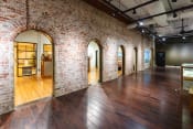 Thumbnail 52 of 84 - a large room with wood floors and brick walls and arched doorways
