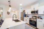 Thumbnail 2 of 38 - Apartments in Broomfield for Rent - Terracina - Kitchen with Granite Kitchen Island, Spacious White Cabinets, and Stainless-Steel Appliances