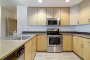 Thumbnail 25 of 36 - a modern kitchen with stainless steel appliances and wooden cabinets