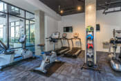 Thumbnail 15 of 24 - a gym with treadmills and other exercise equipment  at Napoleon Apartments, Tacoma, WA 98402