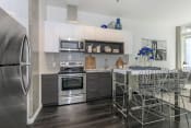 Thumbnail 12 of 24 - a kitchen with white cabinets and stainless steel appliances at Napoleon Apartments, Tacoma