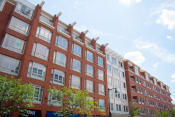Thumbnail 3 of 10 - a red brick building with many windows and trees in front of it