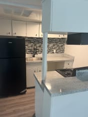 Thumbnail 3 of 14 - a kitchen with white cabinets and a black refrigerator