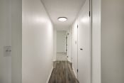 Thumbnail 5 of 14 - a hallway with white walls and wood floors