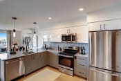 Thumbnail 12 of 30 - a kitchen with white cabinets and stainless steel appliances
