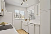 Thumbnail 6 of 44 - a white kitchen with white cabinets and a refrigerator