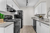 Thumbnail 2 of 27 - a kitchen with white cabinetry and black appliances