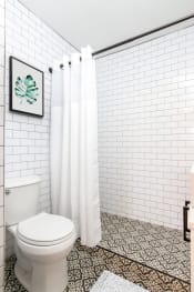 Thumbnail 8 of 12 - a bathroom with white subway tile and a white shower curtain