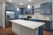 Thumbnail 1 of 48 - a kitchen with blue cabinets and a white island