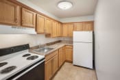Thumbnail 5 of 24 - a kitchen with wood cabinets and white appliances