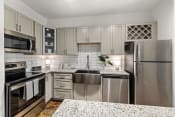 Thumbnail 2 of 14 - a kitchen with white cabinets and granite countertops