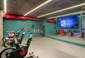 Thumbnail 29 of 41 - a gym with bikes and a projection screen on the wall