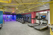 Thumbnail 24 of 41 - a gym with cardio equipment and a colorful wall in a building