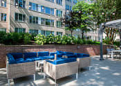 Thumbnail 34 of 41 - a patio with blue couches and chairs in front of a building