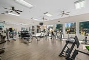 Thumbnail 7 of 25 - a gym with cardio equipment and windows