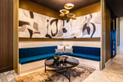 Thumbnail 50 of 75 - blue corner booths with a black table and large paintings on the walls at The Apex at CityPlace, Overland Park, KS