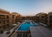 Thumbnail 59 of 75 - view of u shaped apartment complex with an outdoor pool in the center and rows of seating on the patio at The Apex at CityPlace, Kansas