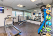 Thumbnail 17 of 36 - a gym with exercise equipment and weights in the corner of a room