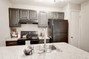 Thumbnail 5 of 29 - a kitchen with gray cabinets and white countertops at Hamilton at Kings Place, Columbia, MD 21046