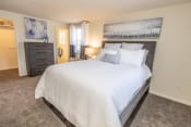 Thumbnail 9 of 22 - a bedroom with a large bed and a dresser at Chapel Valley Townhomes, Baltimore