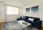Thumbnail 6 of 28 - a living room with a blue couch and a coffee table