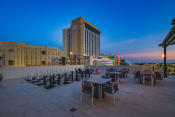 Thumbnail 14 of 14 - a terrace with tables and chairs and a large building in the background at New River, Florida, 33301