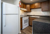 Thumbnail 8 of 16 - a kitchen with a white refrigerator freezer next to a white stove top oven