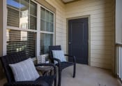 Thumbnail 21 of 31 - the front porch of a home with two chairs and a black door