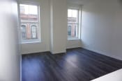 Thumbnail 4 of 22 - an empty living room with wood floors and two windows