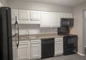 Thumbnail 14 of 41 - a kitchen with white cabinets and black appliances