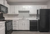 Thumbnail 13 of 41 - a kitchen with white cabinets and black appliances