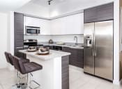 Thumbnail 9 of 14 - a kitchen with white cabinets and stainless steel appliances at Regatta at New River, Fort Lauderdale Florida